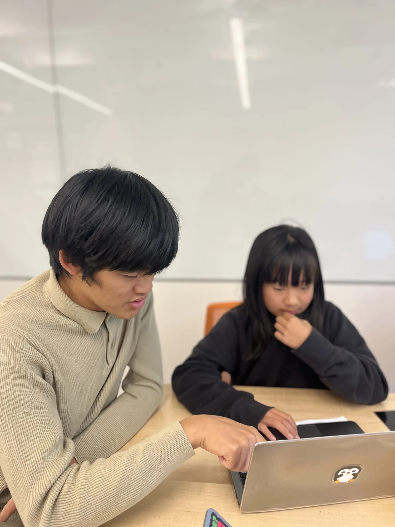 A mentor and a student work through code together on a laptop